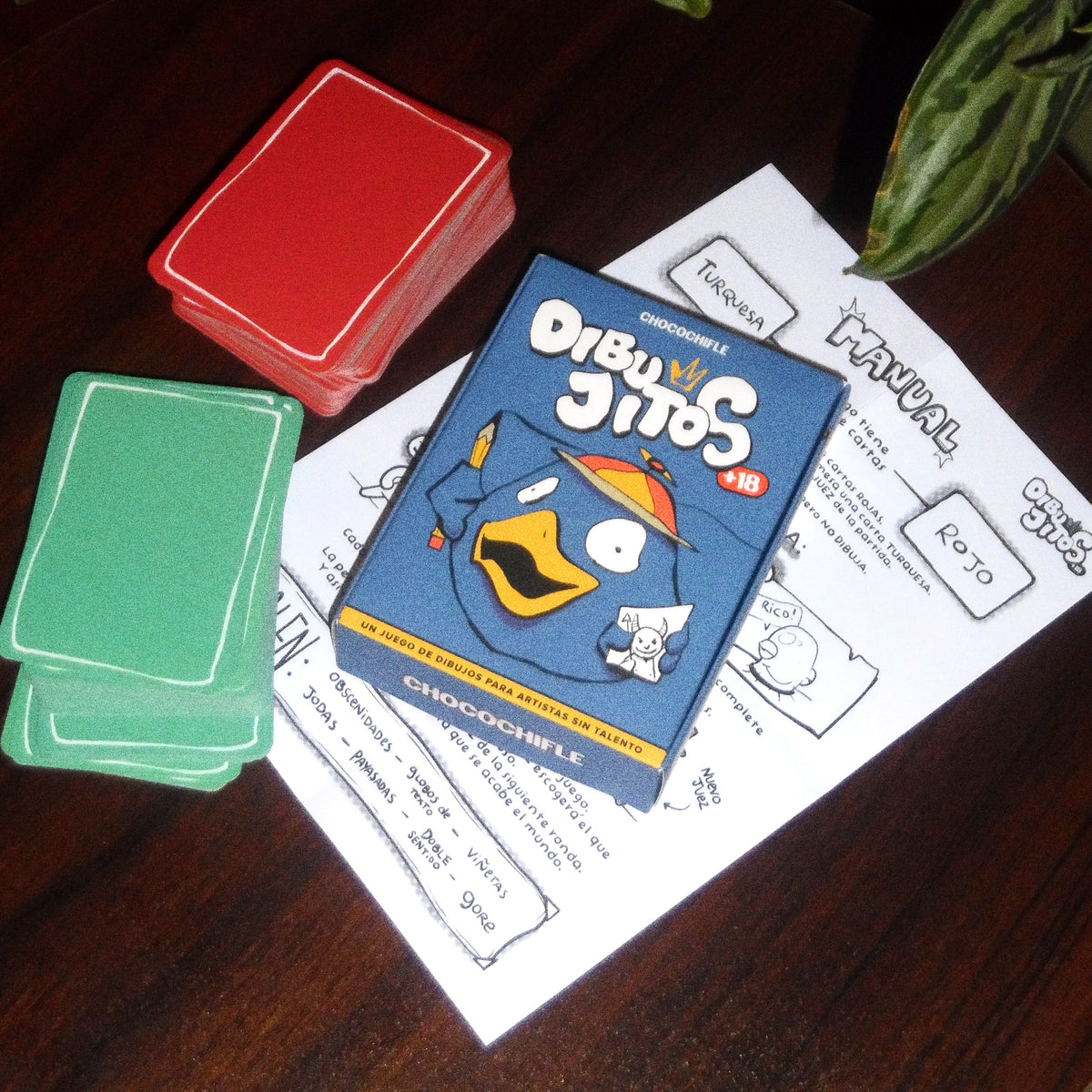 Contenido de Dibujitos: mazo de cartas rojas, mazo de cartas turquesa, caja y manual